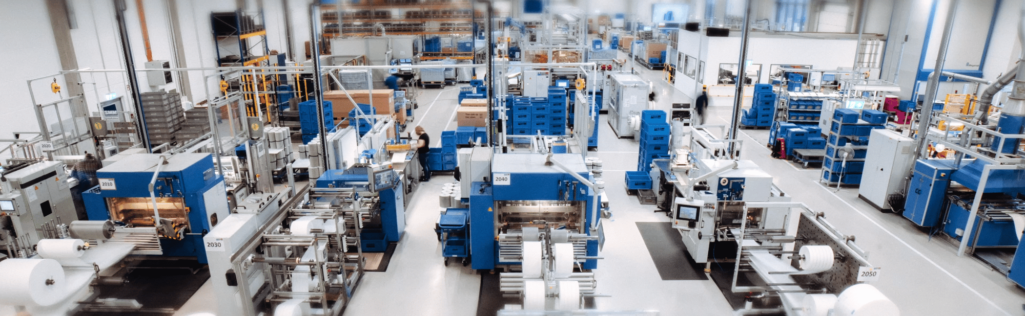 Industrial production hall with automated manufacturing equipment, production lines, and material handling systems Industrial production hall with automated manufacturing equipment, production lines, and material handling systems
