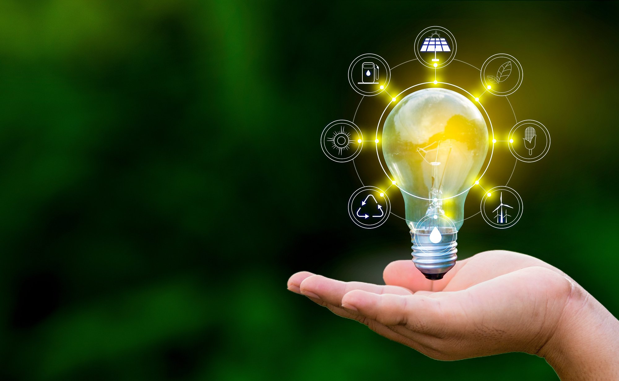 Illuminated light bulb above an outstretched hand, surrounded by digital sustainability and energy-related icons.