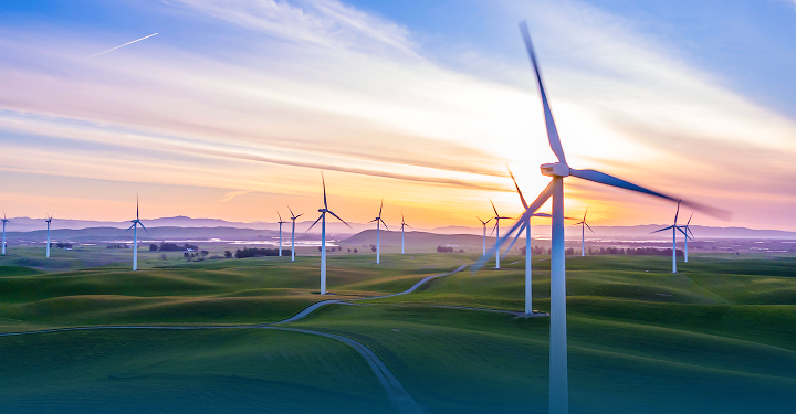 Windkraftanlagen zur Erzeugung erneuerbarer Energie in einer Landschaft bei Sonnenaufgang