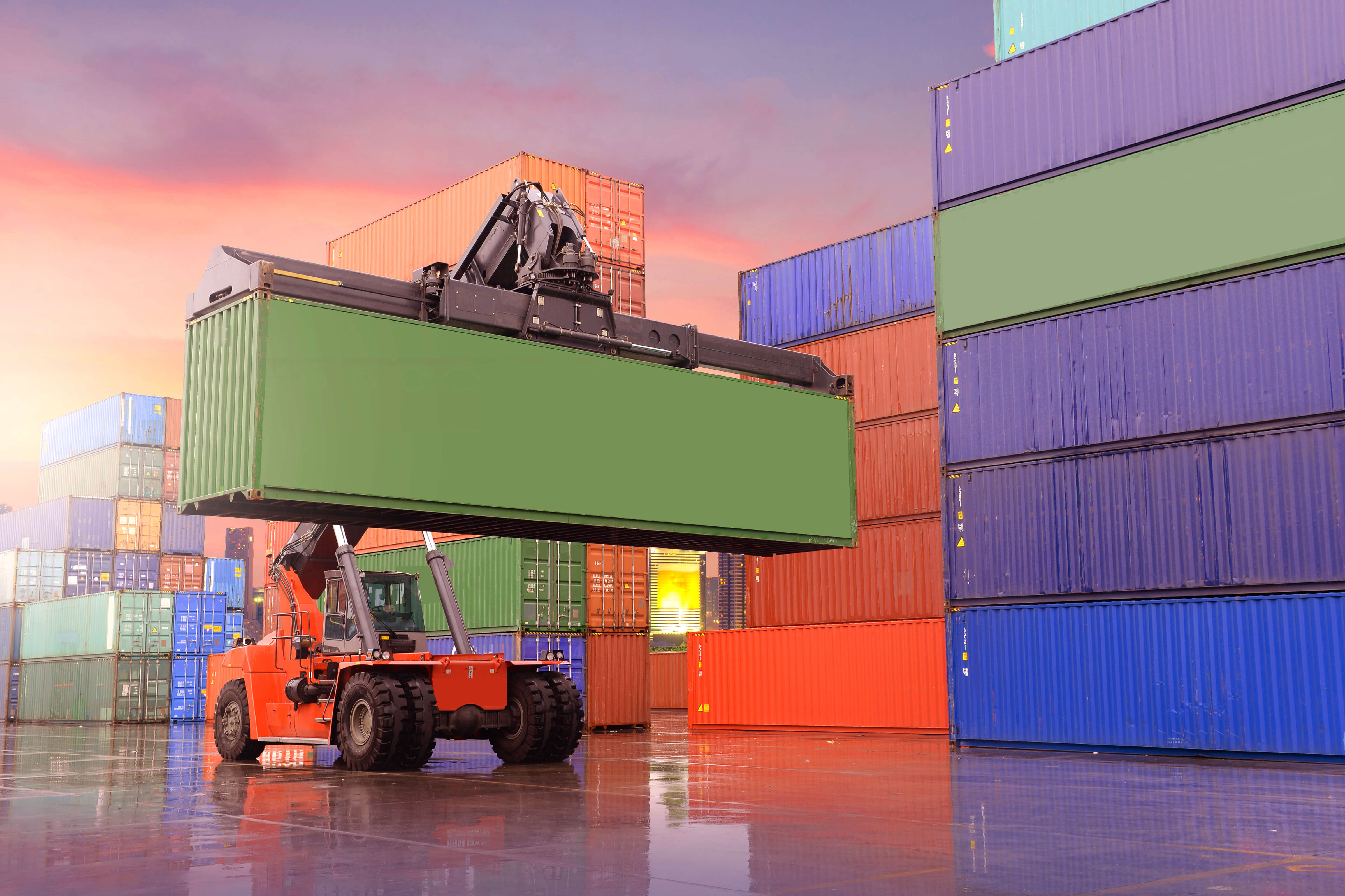 Containerstapler beim Umschlag eines Schiffscontainers in einem Containerterminal