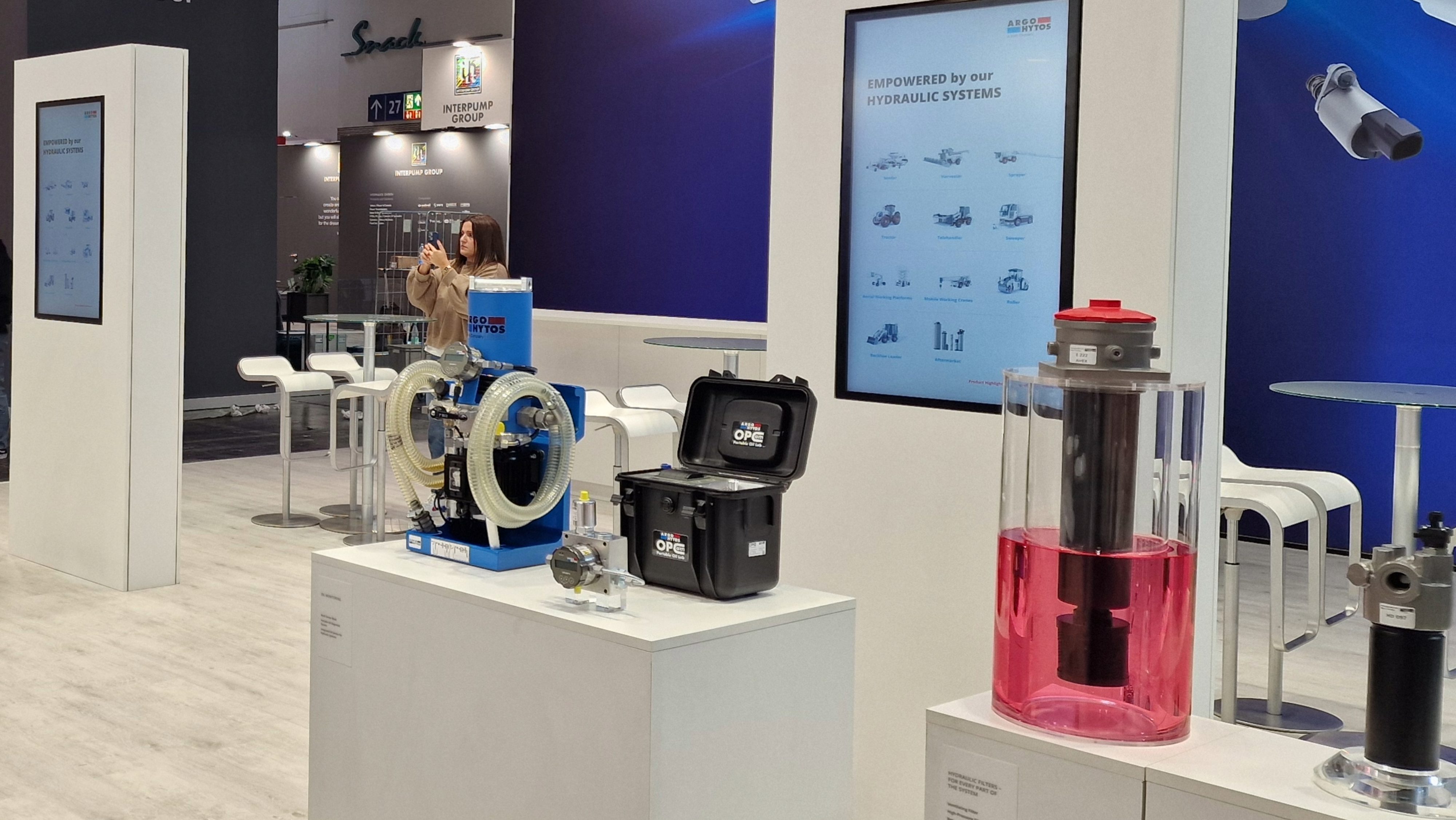 Messestand mit Hydraulikkomponenten, Filterbaugruppen und digitalen Produktinformationsanzeigen.