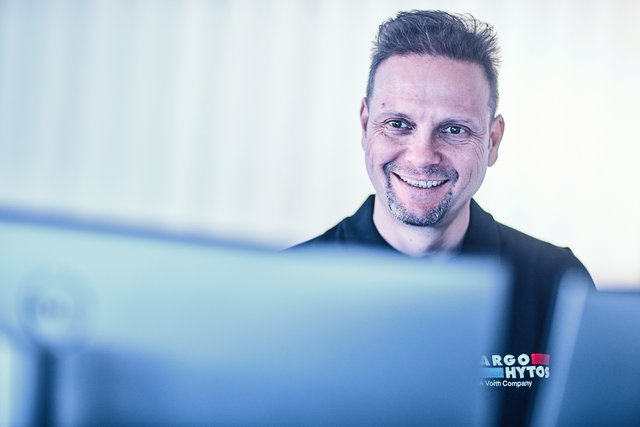 Person an einem Computerarbeitsplatz mit sichtbarem ARGO-HYTOS Branding im Vordergrund
